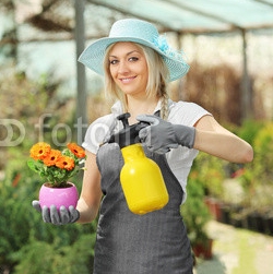 A_beautiful_female_gardener_watering_a_plant.jpg